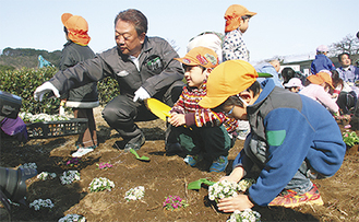 花を植える園児たち（左は倉澤社長）
