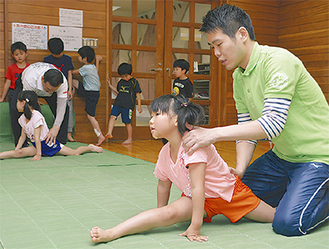 スタッフの体操指導を受ける小学生
