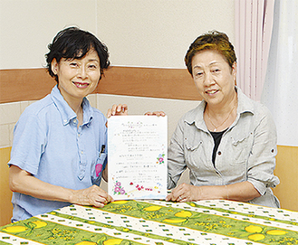 会場で案内書を持つ佐藤さん（右）と「愛あい」の大村さん