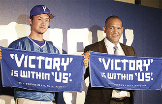 新スローガンが書かれたタオルを手にするラミレス監督（右）と大和選手