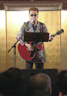 寺の講堂で歌う嘉門さん