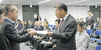大木区長（左）から委嘱状を受け取る太田地区の小峯康盟さん