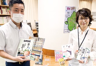 おすすめの本を紹介する佐々木館長（左）とスタッフの嶌田さん