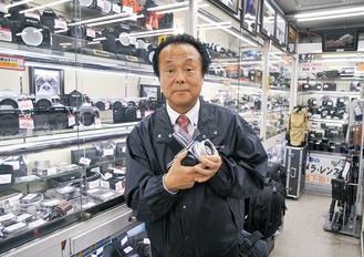 買い取ったカメラを持つ高須賀社長