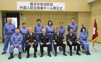 発足したチームのメンバーと有賀消防団長（前列右から３人目）ら