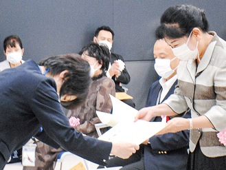 松山区長（左）から賞状を受け取る鮫島由美子さん