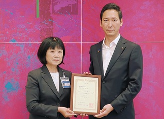 横浜市の大久保智子副市長（左）から感謝状を受け取る商議所の森健二専務理事