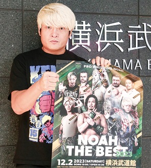 武道館の前でポスターを手にする拳王選手
