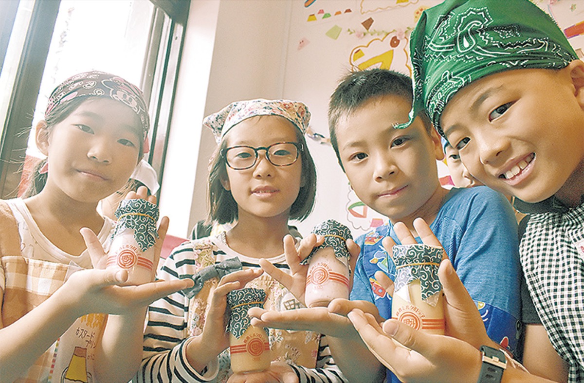 考案したプリンを手にする児童（２０１８年）