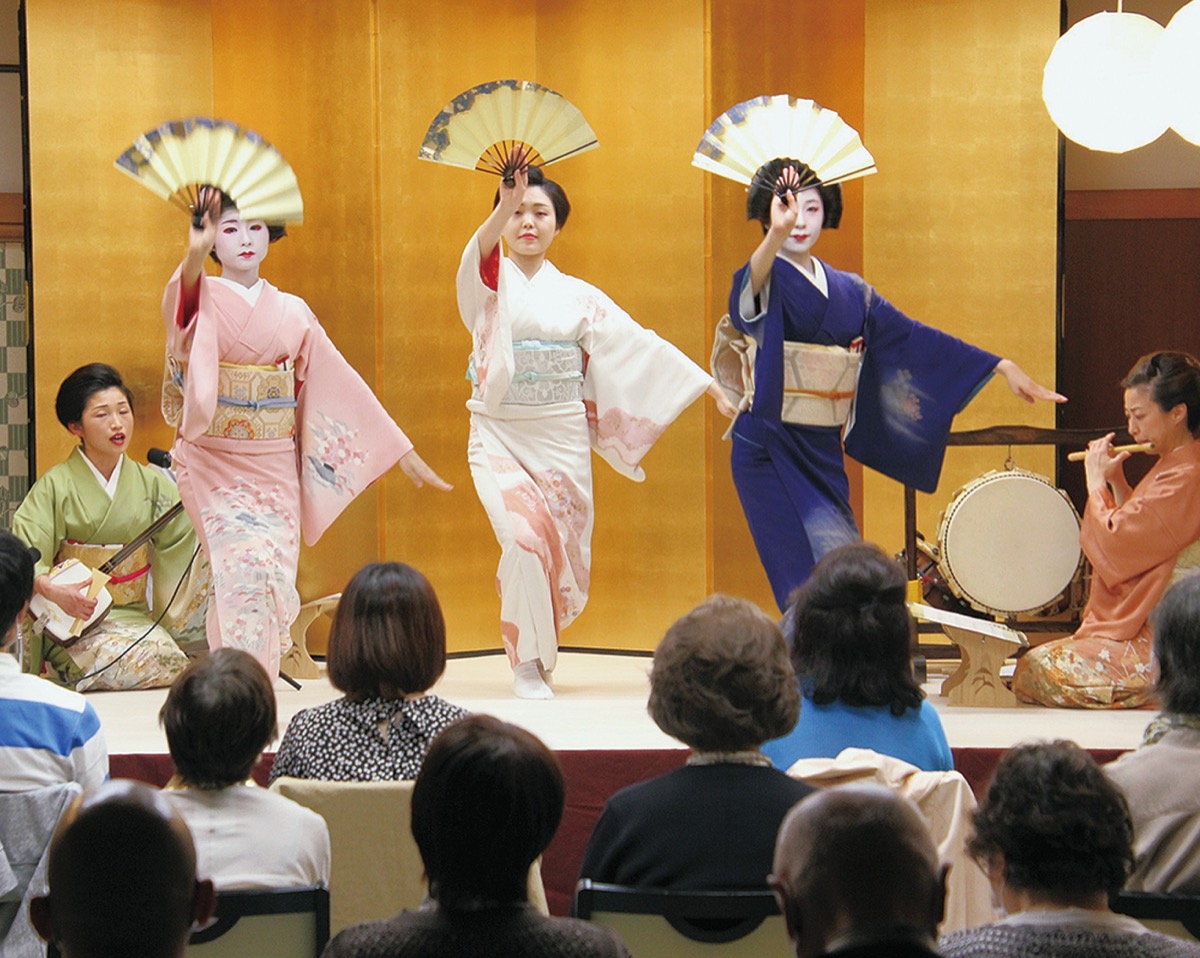 三味線や笛に合わせて舞台で踊る芸者