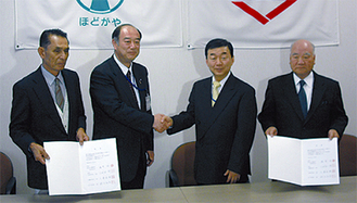 握手を交わす鈴木区長と稲葉取締役社長（中央右）