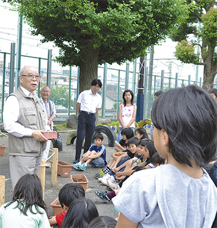 児童に桜の樹について解説する堀川さん（左）