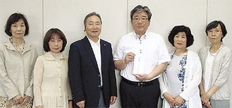 鈴木会長（写真左から３番目）から平井所長（同４番目）に浄財が手渡された〔保土ケ谷区役所提供〕