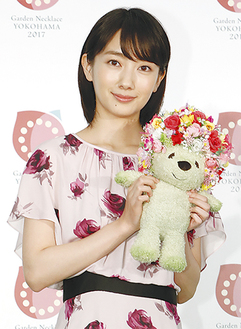 緑化フェアのシンボルキャラクター「ガーデンベア」の人形を手にする女優の波瑠さん