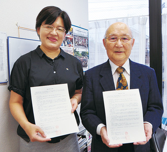 合意書を披露する山崎会長（写真右）と鈴木副社長