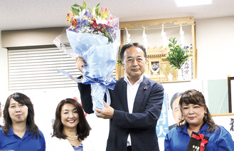 当選確実が報じられ、花束を掲げる島村氏