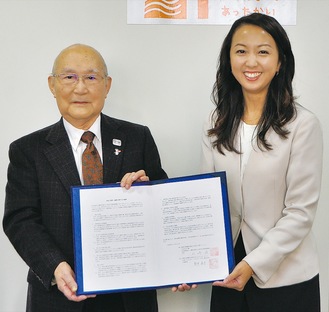 合意書を披露する山崎会長（写真左）と新井広報部長