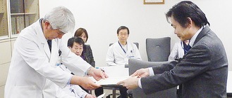 指定書を受ける石原病院長（写真左）