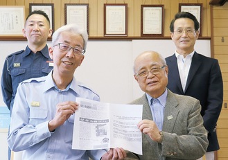 150号の紙面をもつ寺山さん(左)・田中久さんと田中現所長(後列左)、竹内現会長
