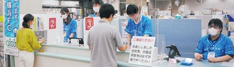 横浜ＦＣのチームカラーのシャツを着て業務にあたる区役所職員