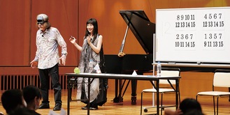 ステージ上で算数マジックを披露する秋山さん（左）と鬼武さん（右）