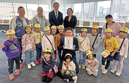 市の職員に義援金を手渡す園児ら（同園提供）