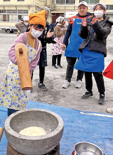 杵と臼を使った餅つきを体験する児童