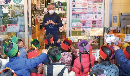 商店街で鬼退治をする園児