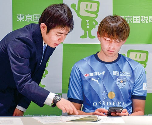 スマホ確定申告を体験するショーン選手（右）