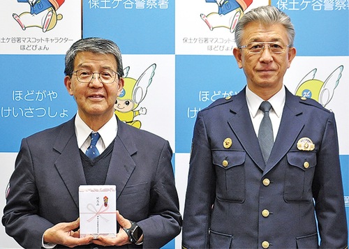 本田署長（右）から記念品を受け取る石川さん