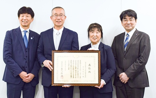 表彰状を手にする高橋理事長（右から２人目）と猪熊校長（左から２人目）