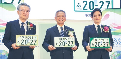 特別仕様のナンバープレートを手にする（左から）河村事務総長、高橋副大臣、山中市長