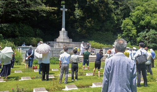 慰霊塔に祈りを捧げる参列者