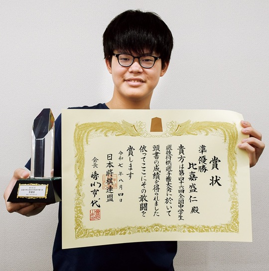 賞状とトロフィーを手にする比嘉さん