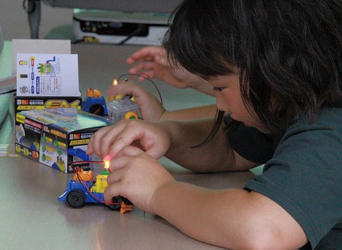 エコカーで発電などの仕組みを学ぶ子ども（提供）