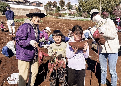 大量の芋を収穫した家族