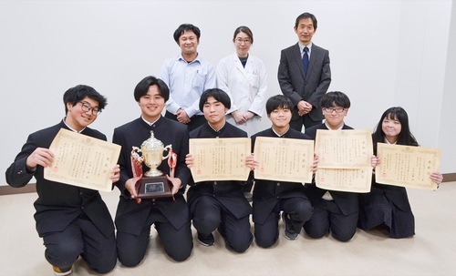 表彰状を手に持つ生徒と教員