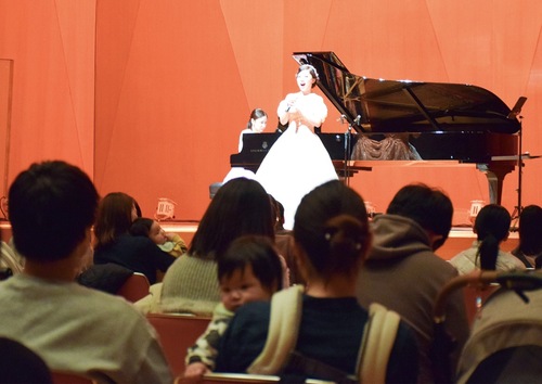 子どもを抱きながらコンサートを楽しむ観客たち