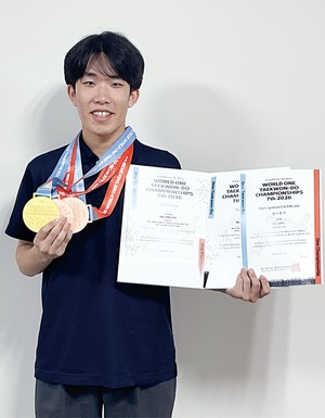３個のメダルと賞状を見せる飯田さん
