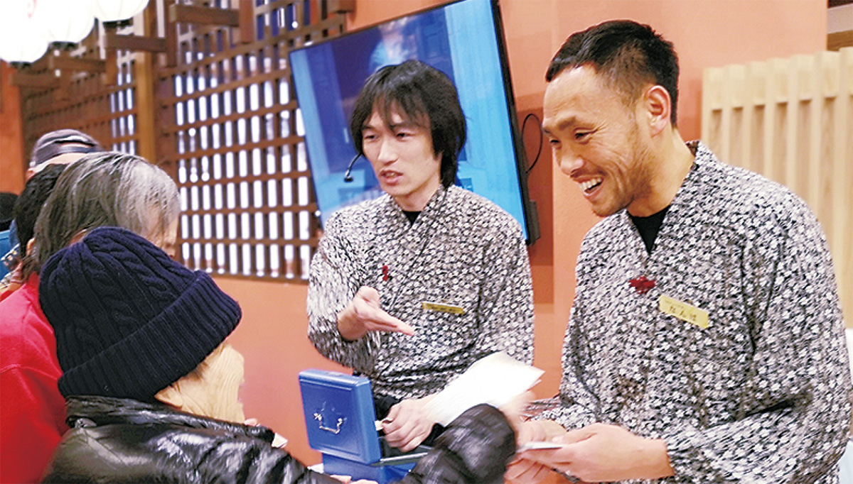 来店者と会話を交わす難波さん（右）
