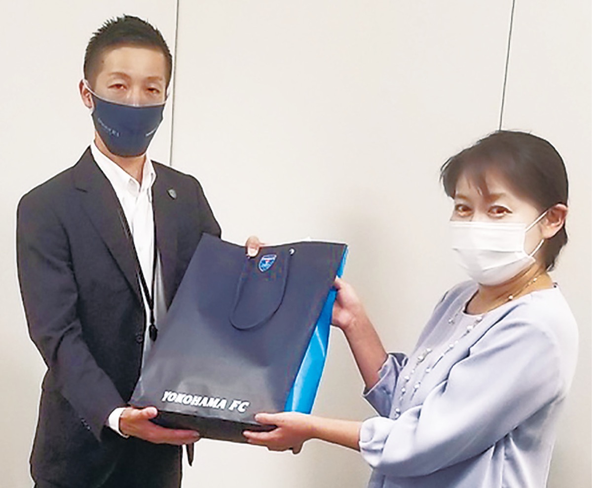 物資を手渡す上尾COO(左)