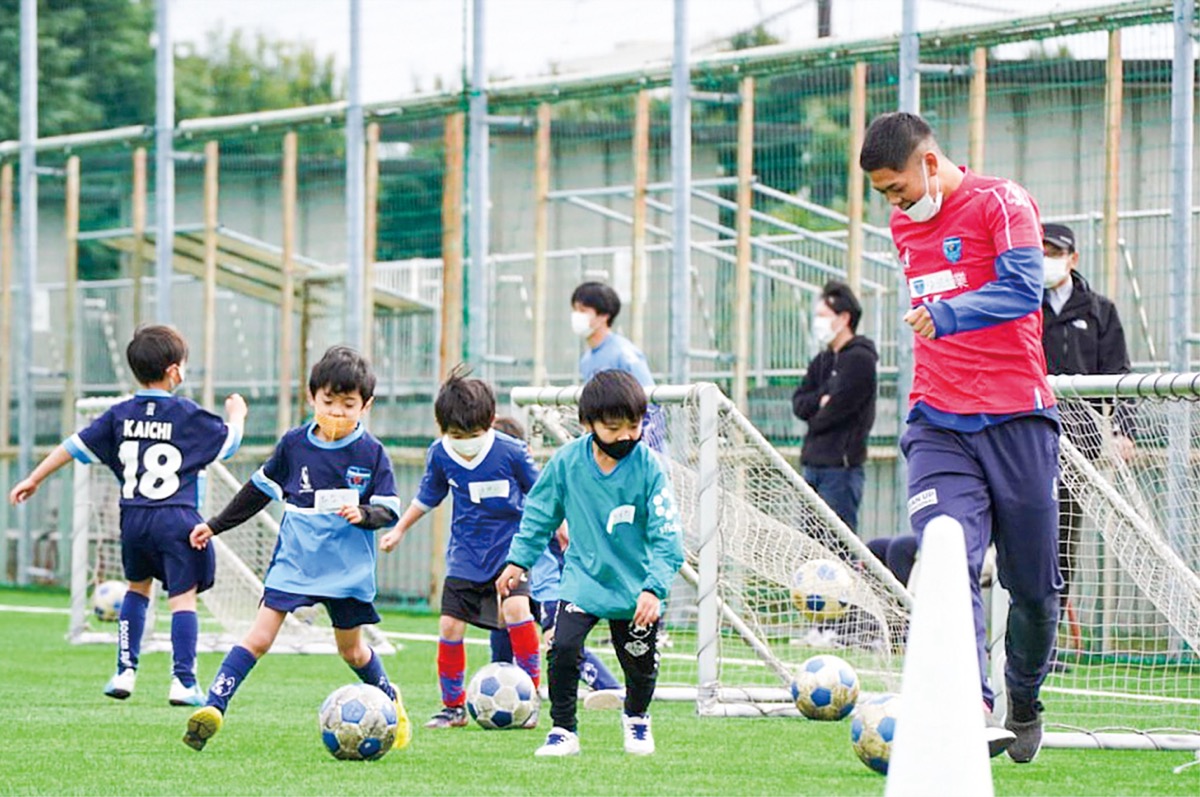 ユースチームに所属する選手とトレーニングする子どもたち