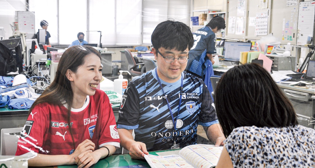 横浜FCのチームカラーのシャツを着て業務にあたる区役所職員