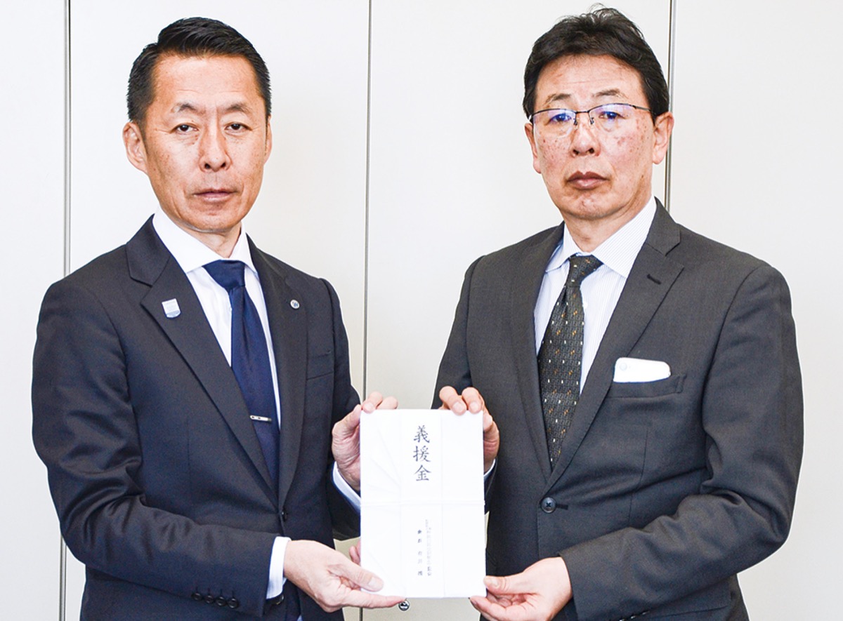 倉田専務理事事務局長（右）に救援金を手渡す有井社長