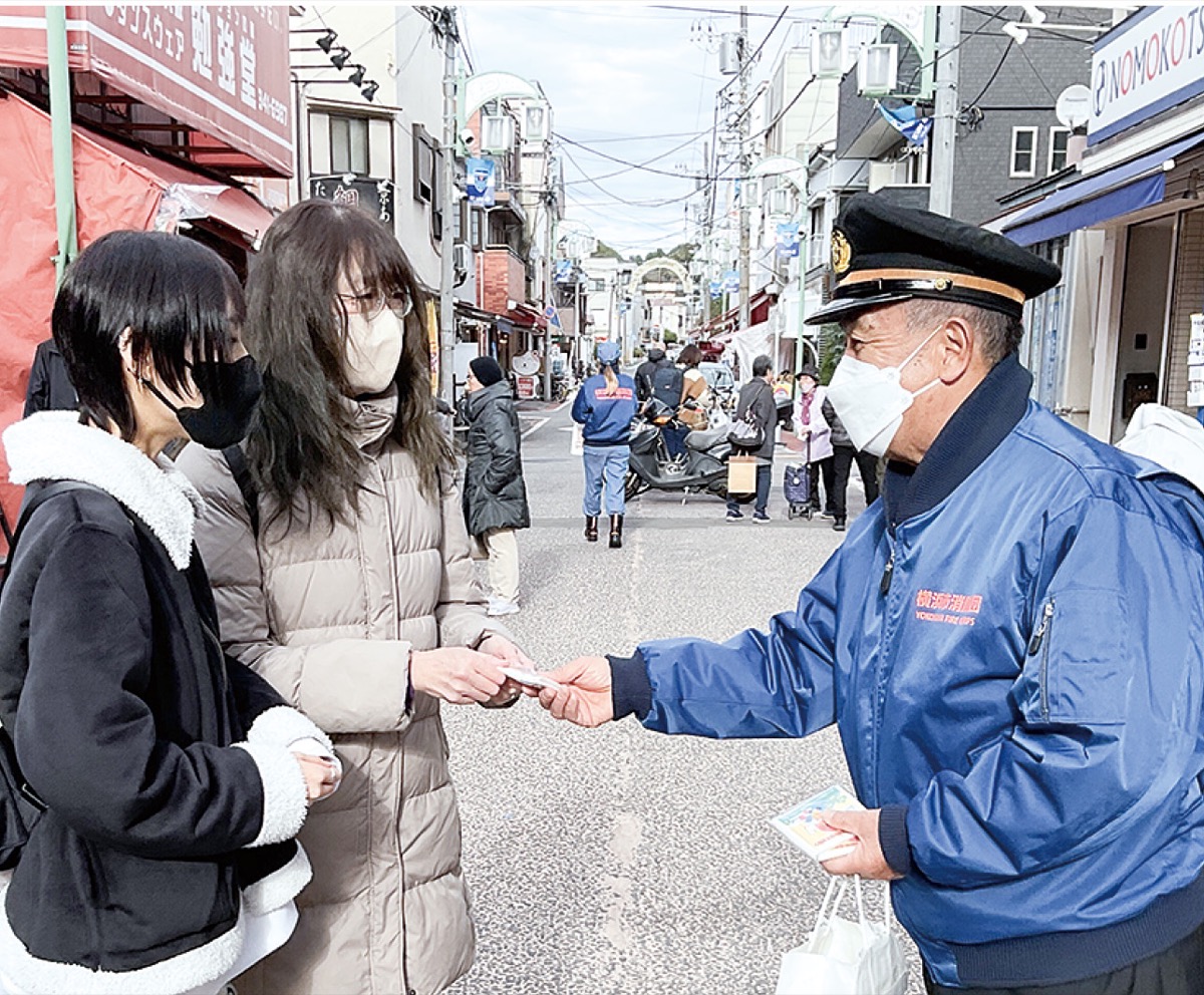 啓発物を配る久保田団長