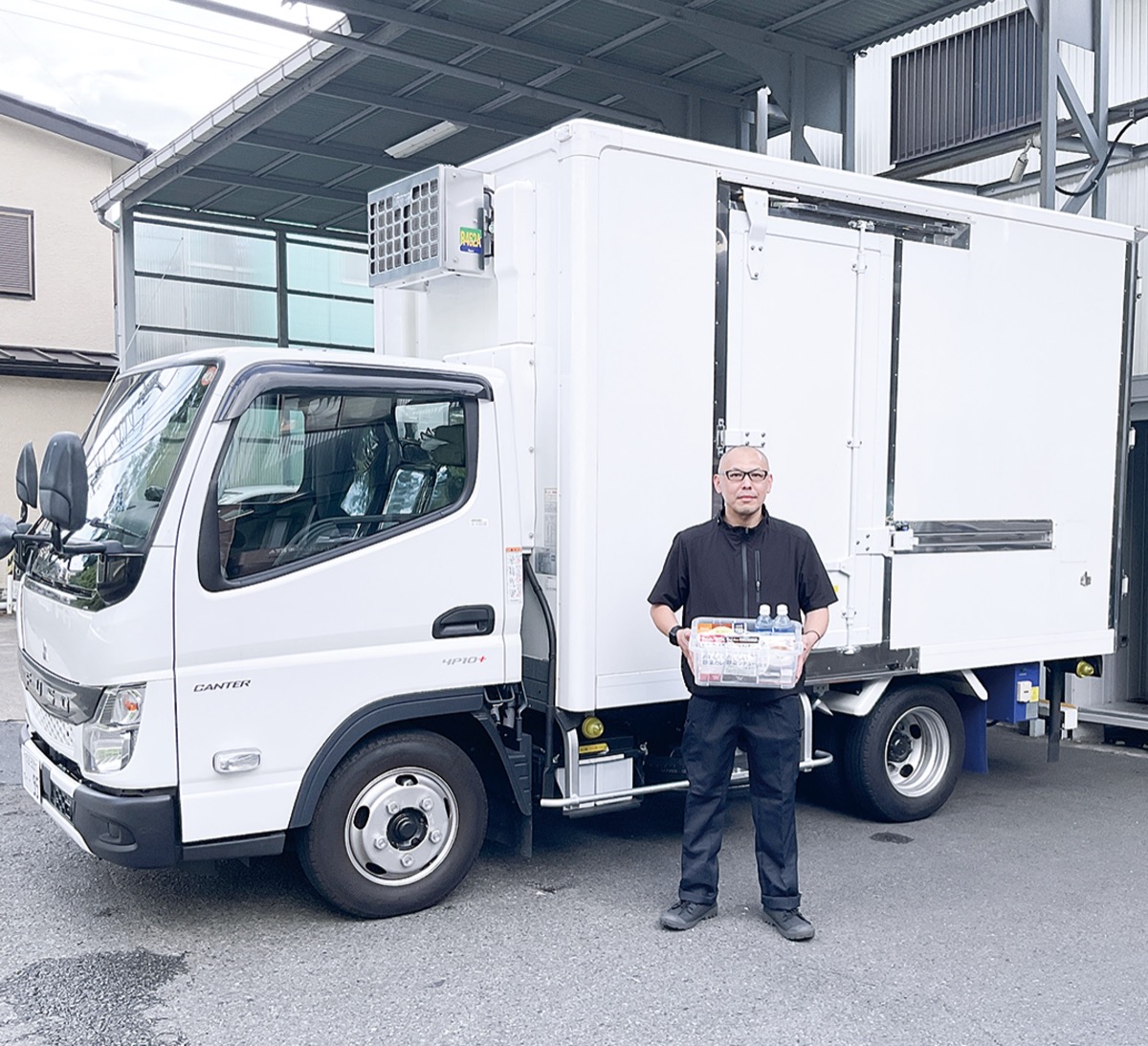 営業車に積まれた常備品を見せる社員
