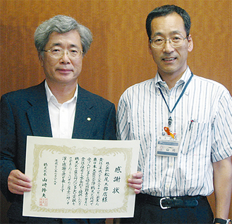 感謝状を受け取った松尾社長（写真左）と山崎区長