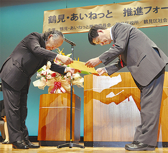 佐藤信男区社協会長（左）から表彰される功労者