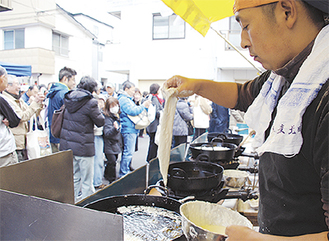 長蛇の列ができる穴子の天ぷら。たくさんの鍋が用意され、魚介商らが手際よくさばいた