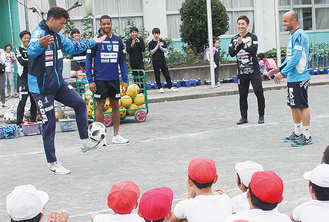 リフティングを披露する選手に歓声を挙げる児童ら